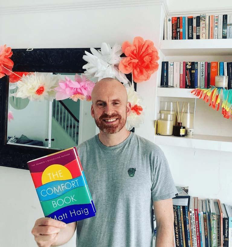 The author Matt Haig holds up a copy of The Comfort Book