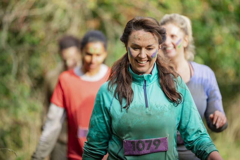 Muddy woman on charity run in country park