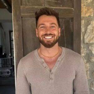 A smiling man with brown hair and a beard