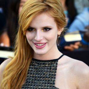 Celebrity, Bella Thorne, smiling at red carpet event.