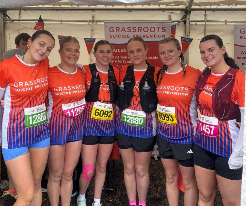 A group of young women pose for photo in marathon outfits.