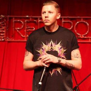 Man with black tshirt holding a microphone.