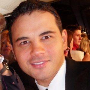 Man with black hair wearing a suit.