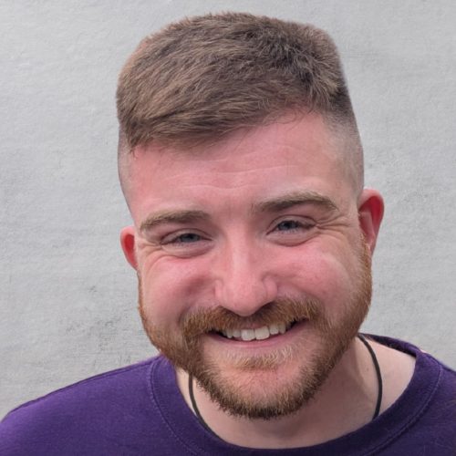 A smiling man with cropped hair and a short beard